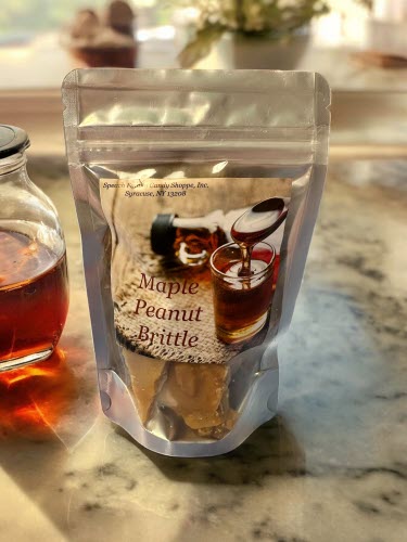 Maple Peanut Brittle Bag on marble counter with jar of maple syrup