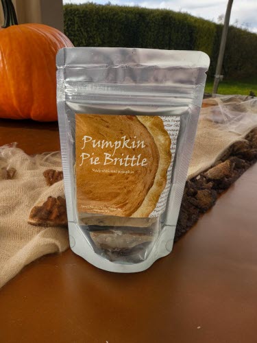 pumpkin pie brittle bag on counter with pumpkin in the background